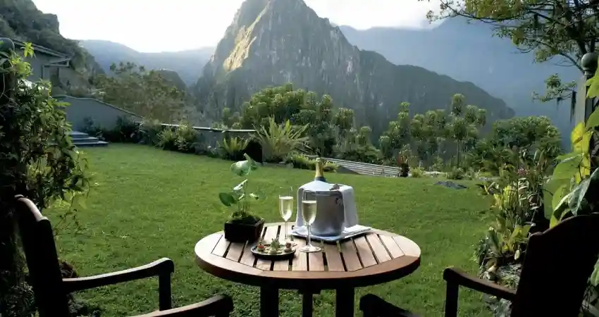 A table with two chairs and a bottle of wine, set in the Best Luxury Hotel in Machu Picchu.