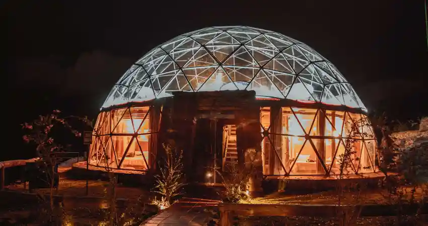 A dome-shaped building, Stardome Peru, illuminated at night against a dark sky.
