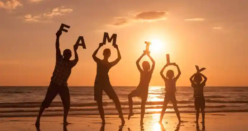 Silhouette of a family on the beach holding the word "family," symbolizing togetherness and luxury travel to Peru.