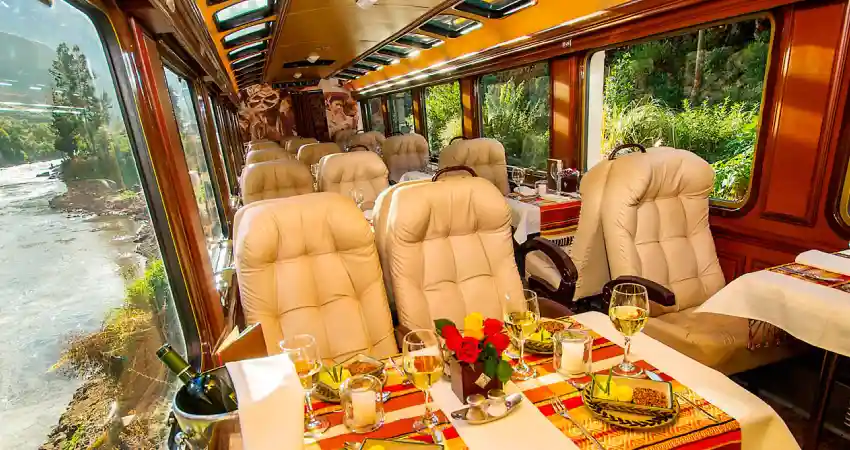 A romantic dining car on a train, elegantly set with candles and fine dining arrangements for an intimate dinner experience.