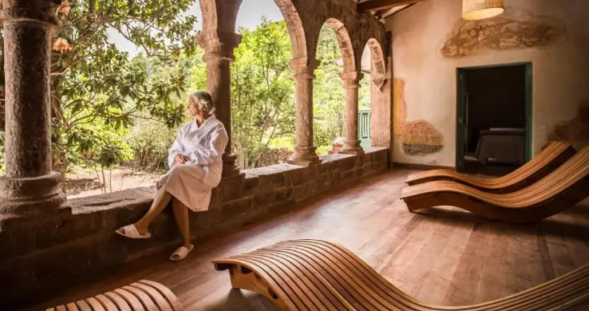 A woman sitting in a chair in a room with wooden furniture at Explora Hotel Sacred Valley.