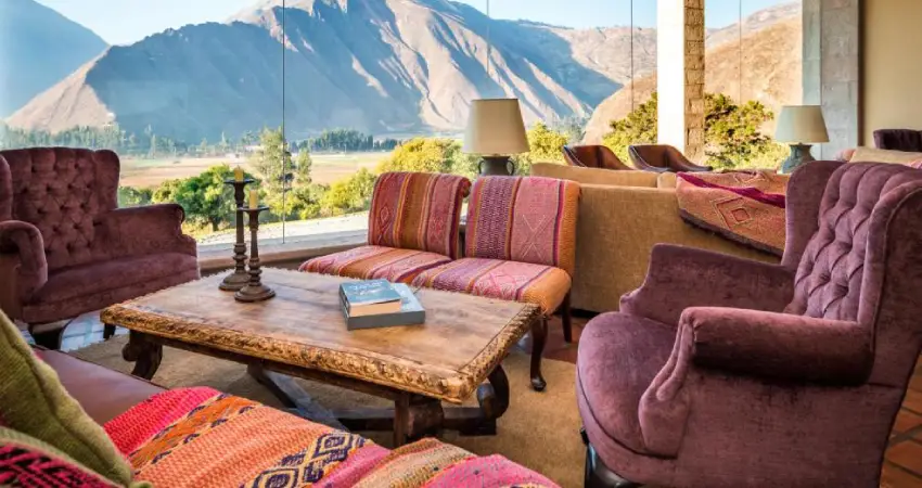 A cozy living room with couches, featuring a stunning mountain view at Inkaterra Sacred Valley.