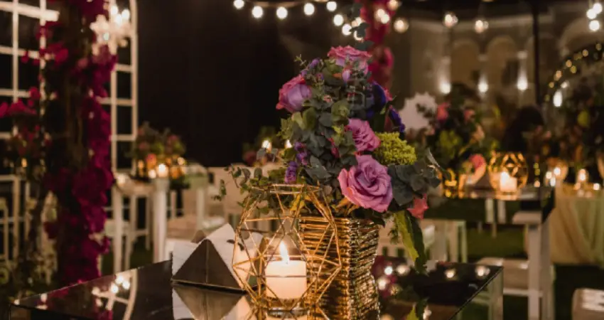 A table at Restaurant Astrid y Gaston adorned with candles and flowers, creating an elegant dining atmosphere.