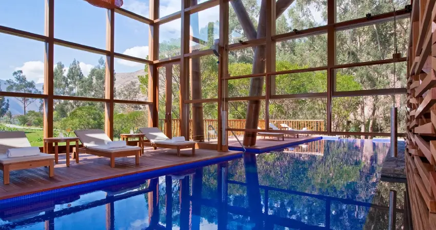 A spacious indoor pool surrounded by wooden walls and large windows, located in the Best Luxury Hotel in Peru.