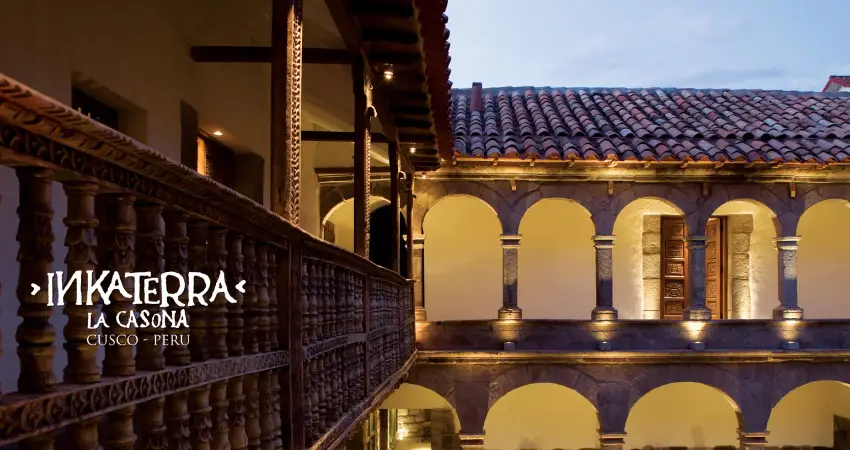 Hotel courtyard at Inkaterra la Casona Cusco featuring a balcony and lush greenery.