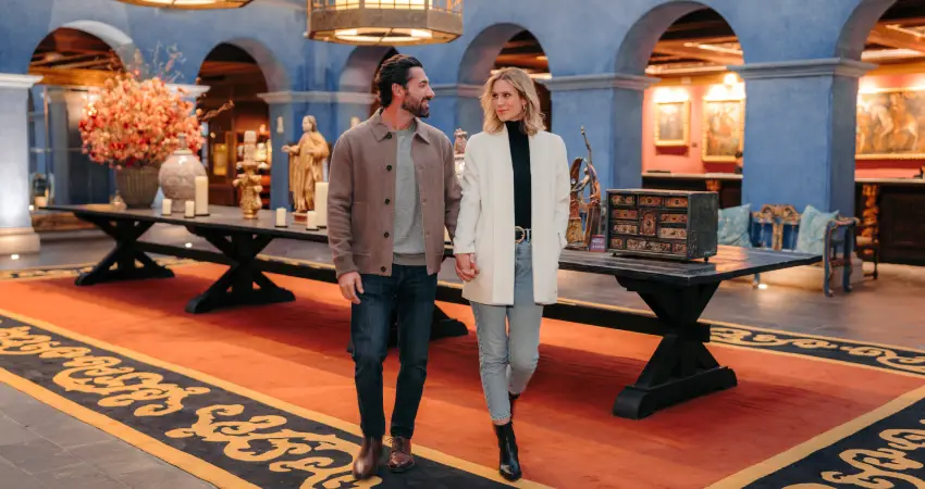 A man and woman walking through the Palacio del Inka museum in Cusco, admiring the exhibits.