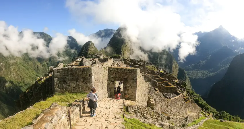 Tourists ascend stairs towards the ancient ruins of Machu Picchu during an all-inclusive vacation in Peru.
