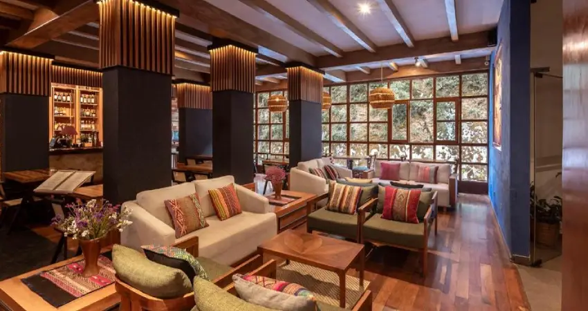 Living room of Casa del Sol Machu Picchu, featuring wooden floors and an array of stylish furniture.