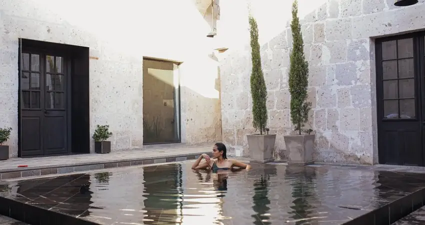 A woman relaxes in a pool within the courtyard of Cirqa Hotel in Peru.