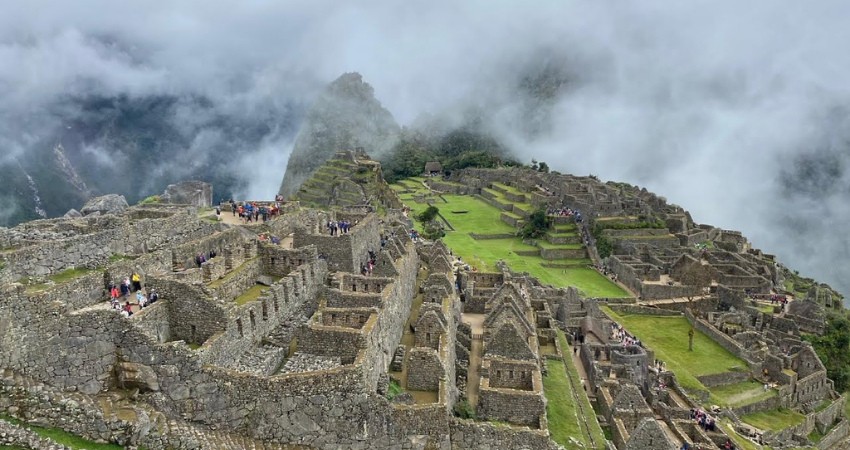 Machu Picchu ruins shrouded in clouds, showcasing the ancient Incan site in February's misty atmosphere.