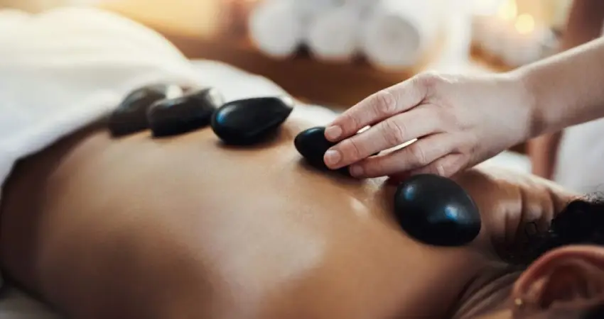 A woman receiving a hot stone massage, promoting relaxation at the best massage spa in Cusco.