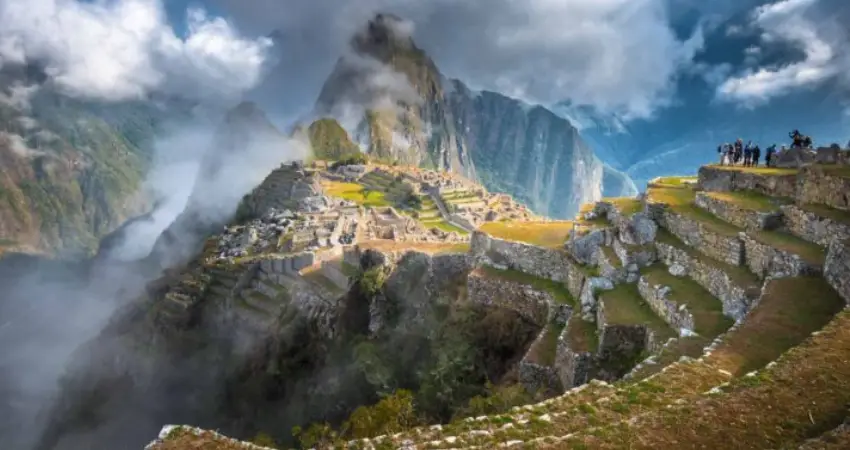 Machu Picchu set against the mountains in September under a cloudy sky.