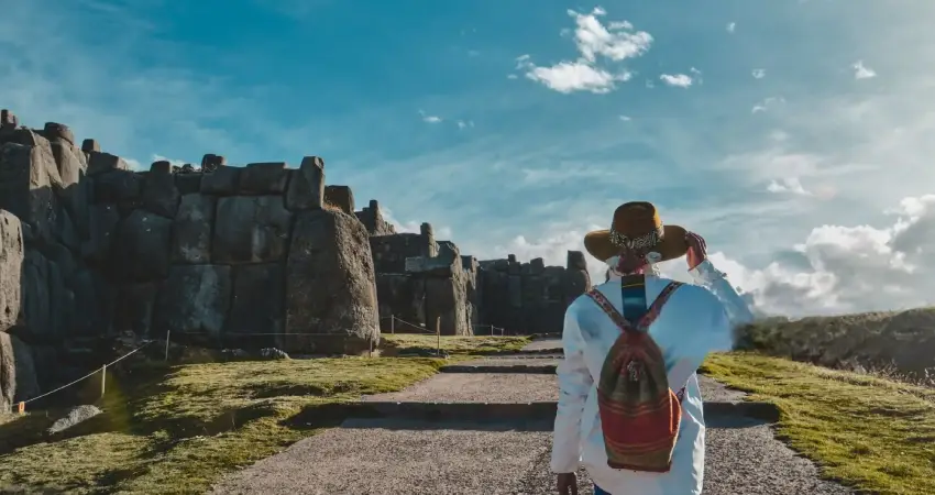 A man in a hat walks along a path beside a stone wall during his 14-day journey in Perú.