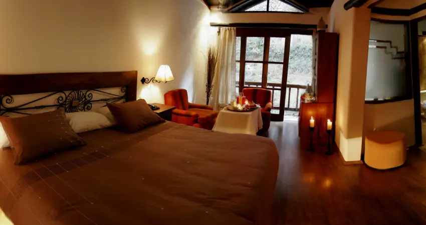 A hotel room at Hatun Inti Boutique Machu Picchu featuring a bed and a polished wooden floor.