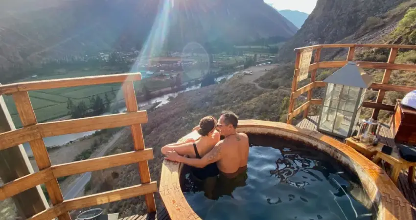 A couple enjoying a hot tub with stunning mountain views at Star Lodge Peru.